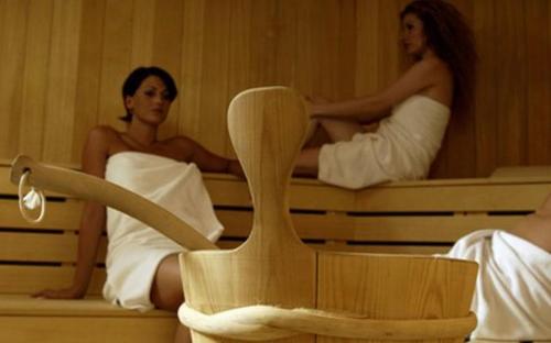 a man and woman sitting on a bed at Pension Sonnenhof in Maranza