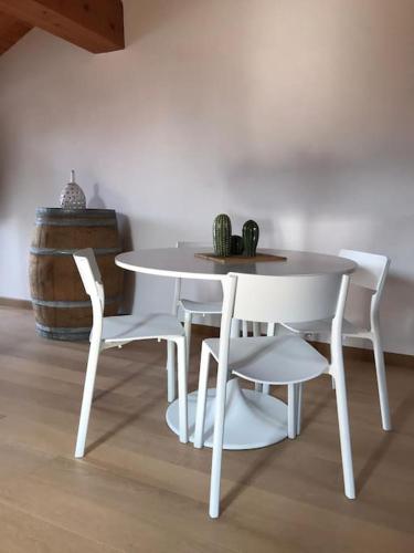 a white table and chairs next to a barrel at Monforte charming 2-5Room Flat in Center TrulloVista in Monforte dʼAlba