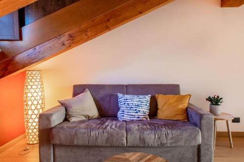 a purple couch with pillows on it in a living room at Monforte charming 2-5Room Flat in Center TrulloVista in Monforte dʼAlba