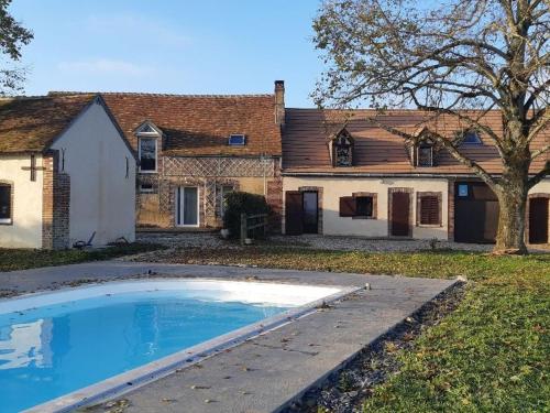 uma piscina vazia em frente a uma casa em Gîte Douchy-Montcorbon-Douchy, 3 pièces, 5 personnes - FR-1-590-105 