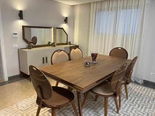 a dining room with a wooden table and chairs at Lovely Apartment New giza in Abū Rawwāsh