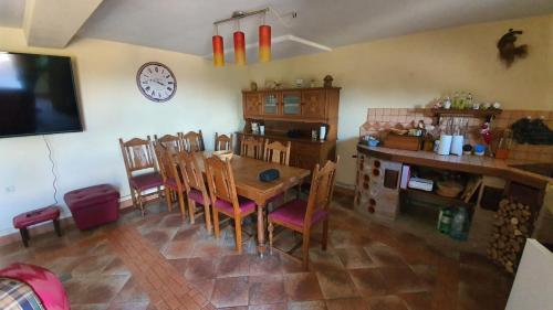 comedor con mesa, sillas y reloj en Family friendly house with a swimming pool Vrbovsko, Gorski kotar - 20331, en Vrbovsko