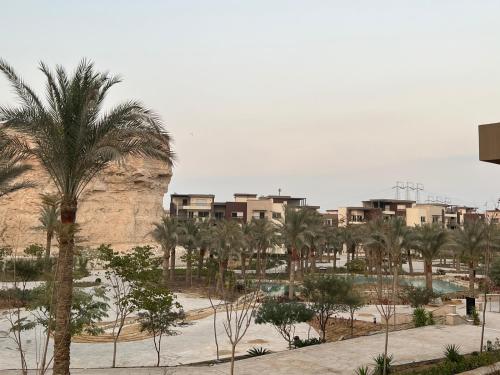 Blick auf eine Stadt mit Palmen und Gebäuden in der Unterkunft Lovely Apartment New giza in Abū Rawwāsh