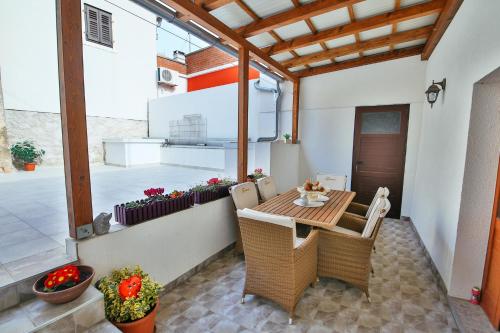 ein Esszimmer mit einem Tisch und Stühlen auf einer Terrasse in der Unterkunft Seaside holiday house Luka, Dugi otok - 20212 in Sali