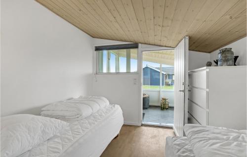 Zimmer mit 4 Kissen auf einem Sofa und einem Kühlschrank in der Unterkunft Beautiful Home In Spttrup With Kitchen in Lihme