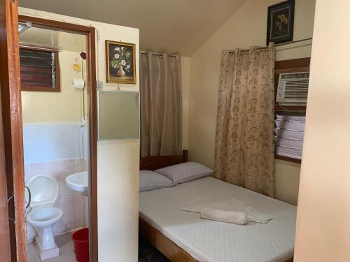 a small room with a bed and a toilet at Blessed Inn in San Miguel