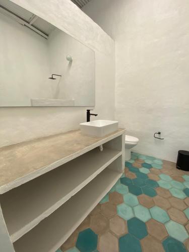 a bathroom with a sink and a toilet with a mirror at Casa menta. Hospédate a 5 minutos de Honda in Honda