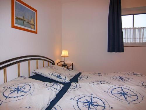 1 dormitorio con 1 cama con colcha y un barco. en Holiday resort Lemkenhafen, Fehmarn-Lemkenhafen en Lemkenhafen auf Fehmarn