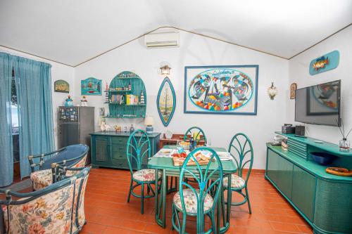 une cuisine avec une table et des chaises ainsi qu'une télévision dans l'établissement Affitti Brevi Toscana - 50 passi dal mare, à Fonteblanda