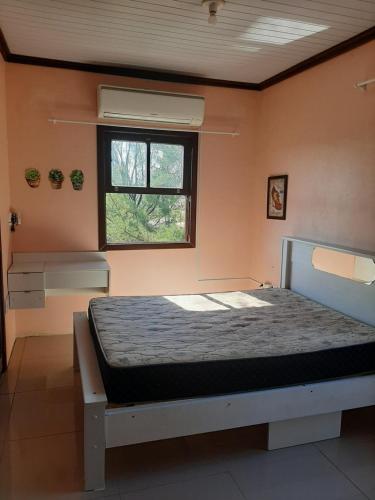 1 dormitorio con 1 cama en una habitación con ventana en Vista da Guarita en Torres