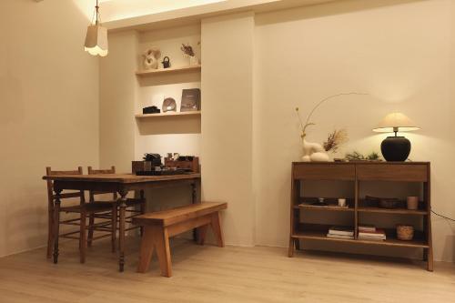 Cette chambre comprend un bureau, une table et une étagère. dans l'établissement Yueshe House, à Jiaoxi