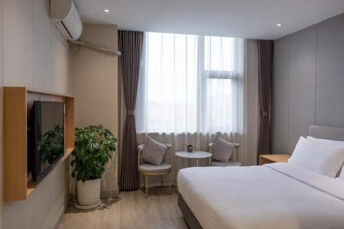 a hotel room with a bed and a tv at Shanghai JOYFUL YARD Hotel-Free shuttle bus to Pudong Airport and Disneyland in Shanghai