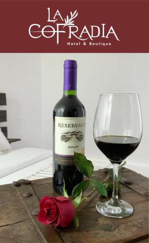 a bottle of red wine next to a glass of wine at Hotel La Cofradía in Zacatlán