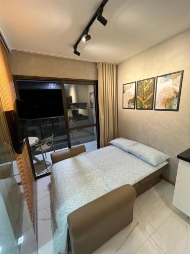 um quarto com uma cama e uma televisão de ecrã plano em Apartamento luxuoso a poucos metros da praia em Salvador
