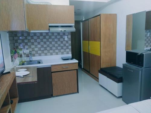 a small kitchen with a sink and a refrigerator at Grand reviera in the front of famous sunset of manila with stunning beauty of dolomite sand in Manila