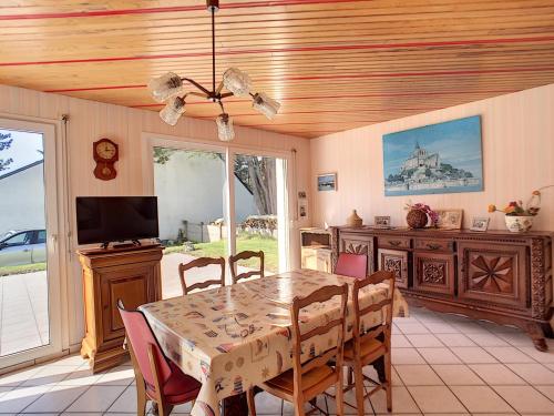 une salle à manger avec une table et des chaises dans l'établissement Villa à 100m de la Plage avec Jardin, Terrasse, et Proche Commerces - FR-1-361-95, à Jullouville