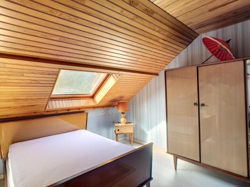 une chambre avec un lit et un plafond en bois dans l'établissement Villa à 100m de la Plage avec Jardin, Terrasse, et Proche Commerces - FR-1-361-95, à Jullouville