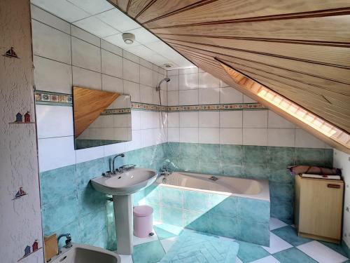 une salle de bain avec un lavabo et une baignoire dans l'établissement Villa à 100m de la Plage avec Jardin, Terrasse, et Proche Commerces - FR-1-361-95, à Jullouville