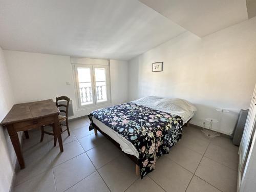 Schlafzimmer mit einem Bett, einem Tisch und einem Fenster in der Unterkunft Appartement Port-Vendres, 2 pièces, 4 personnes - FR-1-309-216 in Port-Vendres