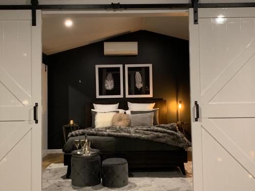 a bedroom with a bed with a black wall at Kudos Villas - Hepburn Springs in Hepburn Springs