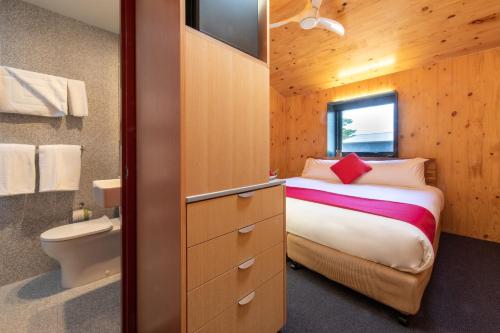 um pequeno quarto com uma cama e uma casa de banho em Iron Creek Bay Estate em Sorell