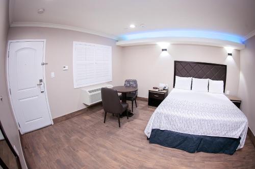 a bedroom with a bed and a desk and a table at Diamond Bell Inn & Suites in Bell