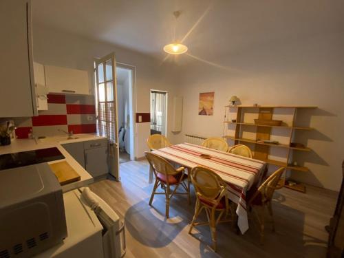 une cuisine avec une table et des chaises dans une pièce dans l'établissement Maison de charme à 100m de la plage, 2 chambres, cour commune et animaux acceptés - FR-1-413-116, à Capbreton