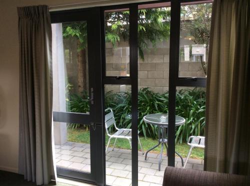 an open door to a patio with a table and chairs at Chancellor Motor Lodge and Conference Centre in Palmerston North