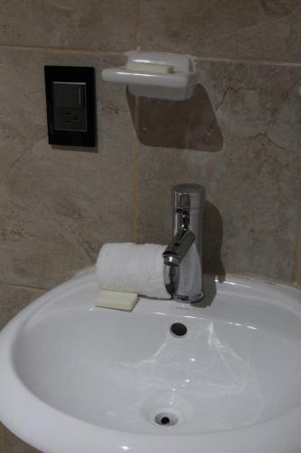 a white sink in a bathroom with a roll of toilet paper at Casa Diez-59 Guanajuato Capital in Guanajuato