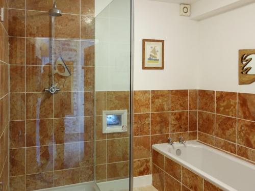 a bathroom with a shower and a bath tub and a bath tub at Turneys Cottage - Uk42115 in Bodmin