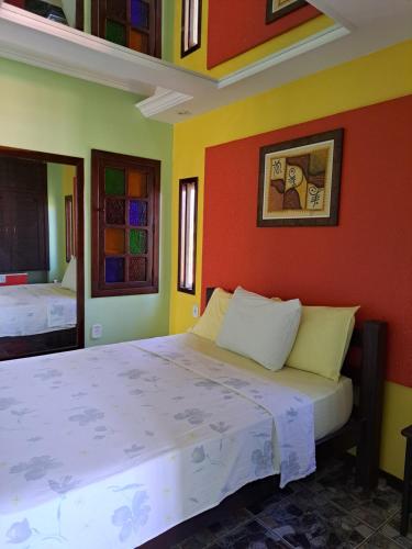 a bedroom with two beds with colorful walls at Recanto do Mergulhão in Maceió