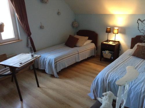a bedroom with a bed and a table and a desk at Le Grand Gîte in Dorengt