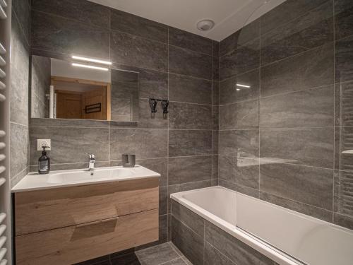 een badkamer met een bad en een wastafel bij Appartement Valmorel, 5 pièces, 8 personnes - FR-1-356-417 in Valmorel