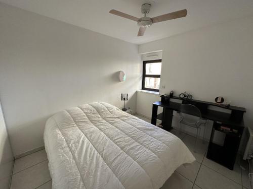 biała sypialnia z łóżkiem i biurkiem w obiekcie Appartement T3 avec terrasse, centre Port-Vendres, calme et proche des quais, 6 personnes - FR-1-309-365 w mieście Port-Vendres