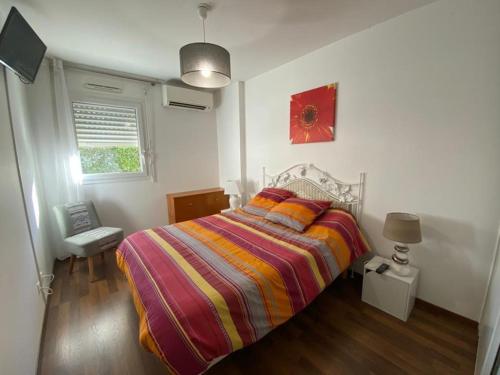 1 dormitorio con 1 cama con una manta a rayas de colores en Appartement Capbreton, 2 pièces, 4 personnes - FR-1-413-208 en Capbreton