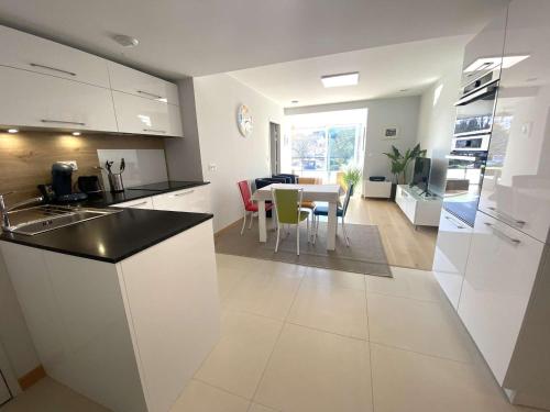 une cuisine et un salon avec une table et des chaises dans l'établissement La Forêt-Fouesnant, appart. neuf, centre, proche golf, parking privatif - FR-1-481-130, à La Forêt-Fouesnant