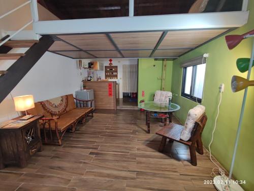 salon z zielonymi ścianami, stołem i krzesłami w obiekcie Humble Room w mieście Hualian
