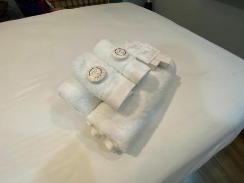 a pile of towels sitting on top of a bed at Rain Airport Bed and Breakfast in Manila