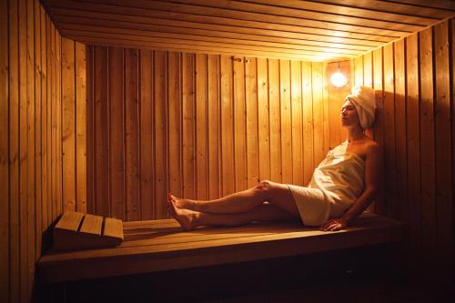 una mujer está sentada en una sauna en VVF Pays Basque Sare La Rhune, en Sare