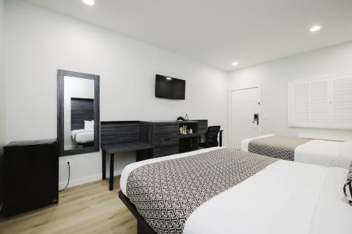 a hotel room with two beds and a mirror at Sapphire Inn & Suites in Deer Park