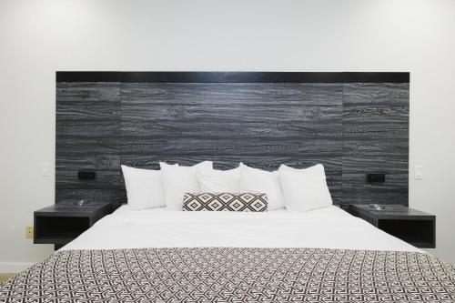 a bedroom with a large bed with white sheets and pillows at Sapphire Inn & Suites in Deer Park