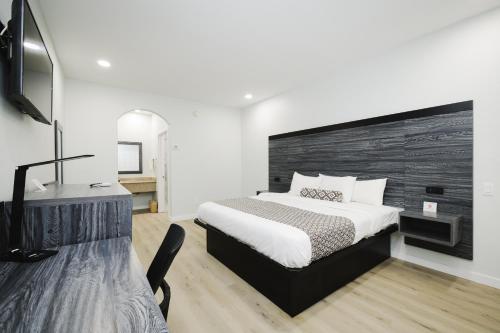a bedroom with a bed and a desk and a television at Sapphire Inn & Suites in Deer Park