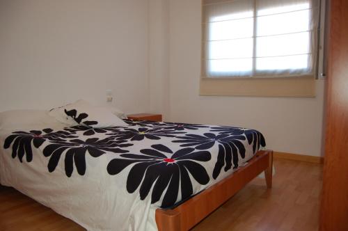 a bedroom with a bed with a black and white comforter at Apartamentos Santa Barbara II in Santa Bárbara