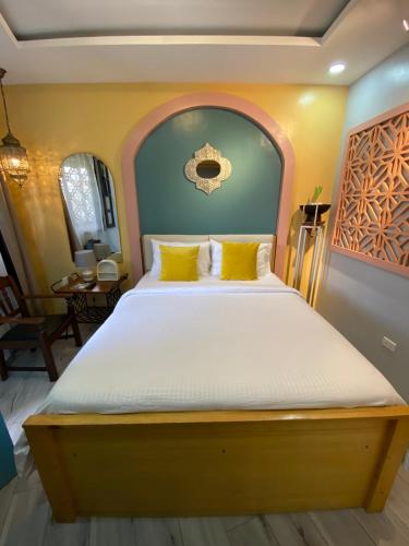 a bedroom with a large bed with yellow pillows at Rain Airport Bed and Breakfast in Manila