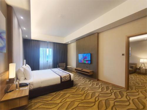 a hotel room with a bed and a flat screen tv at Sunway Putra Hotel Kuala Lumpur in Kuala Lumpur