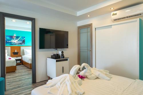 a hotel room with a bed with a tv on the wall at FUNPLACE BEACH in Himmafushi