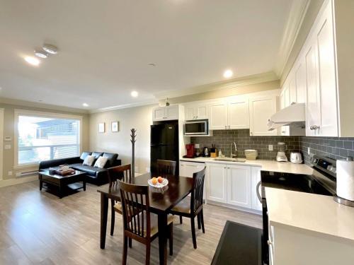 cocina y sala de estar con sofá y mesa en New two-bedroom legal suite with parking, en White Rock
