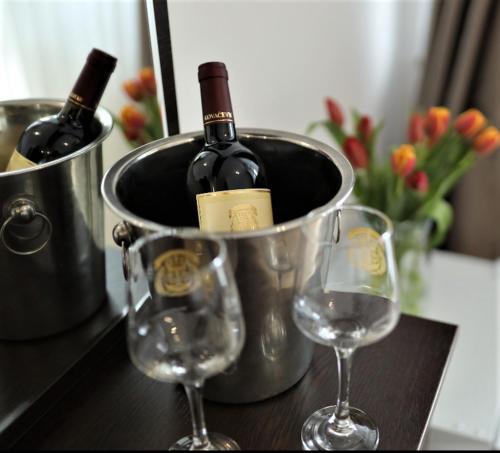 two wine glasses and a bucket of wine bottles at Apartment Vukica with free parking in Petrovac na Moru