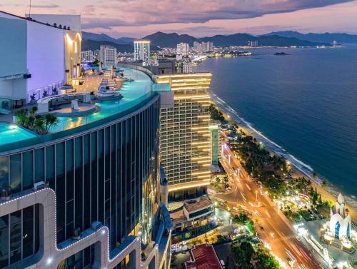 a view of a city at night with the ocean at PANORAMA Condotel by HLG in Nha Trang