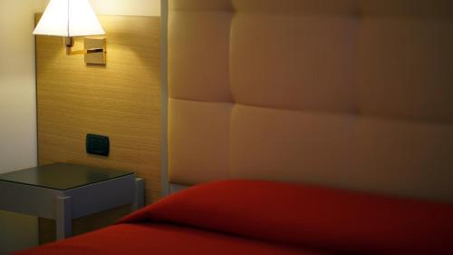 a bedroom with a bed and a table and a lamp at Garden Hotel in Arezzo